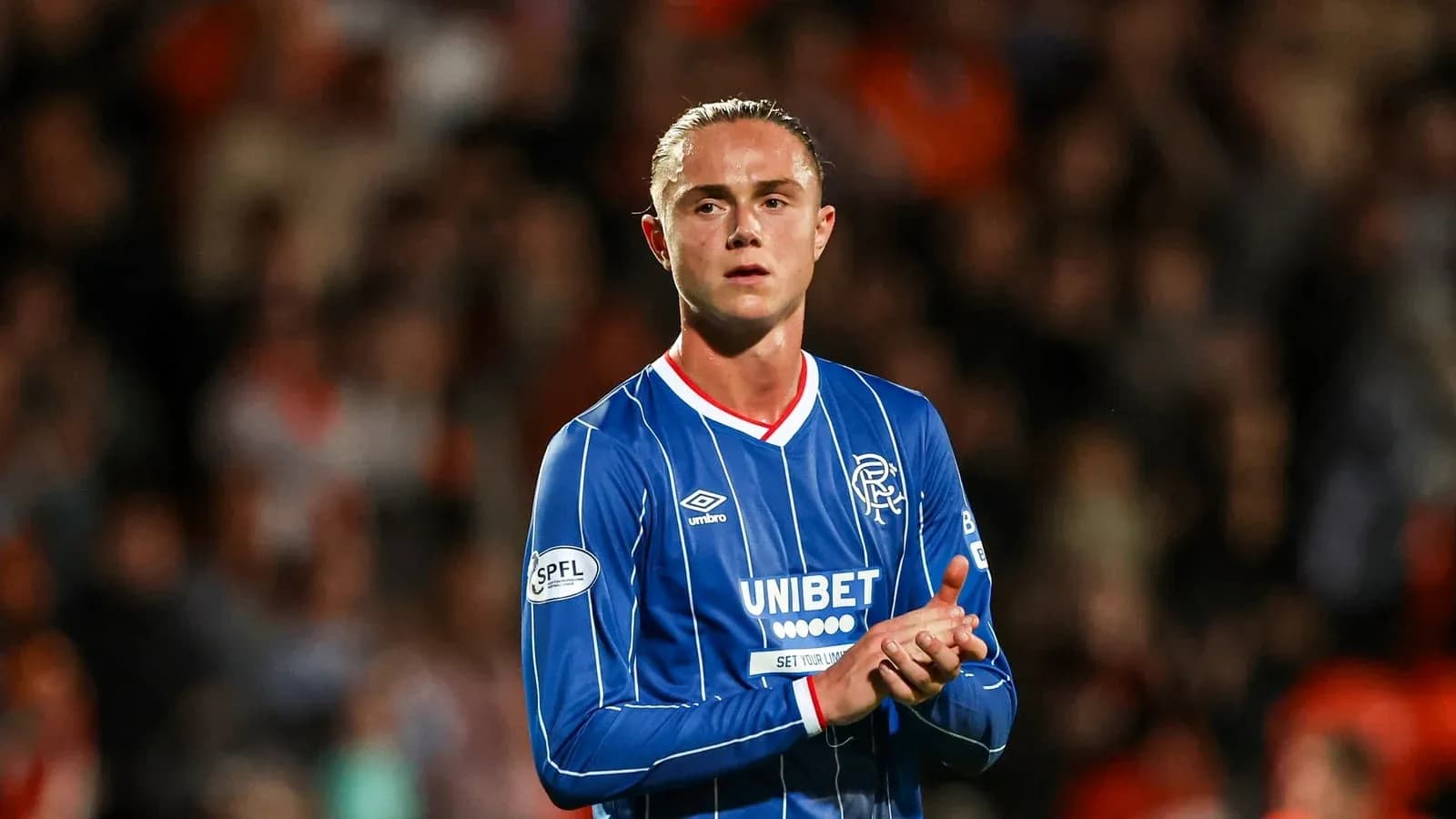 Player clapping in Rangers FC blue jersey