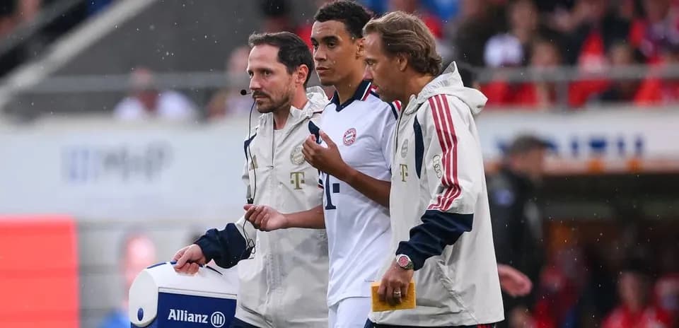 Player being assisted off the field by staff