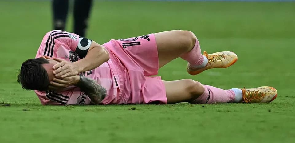 Player lying on ground holding face in pain