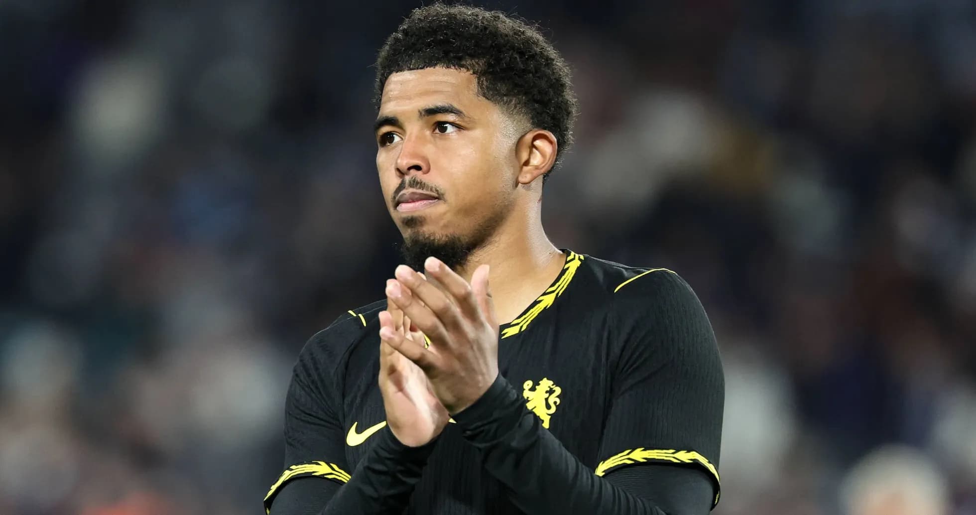 Player applauding fans after match wearing Chelsea kit