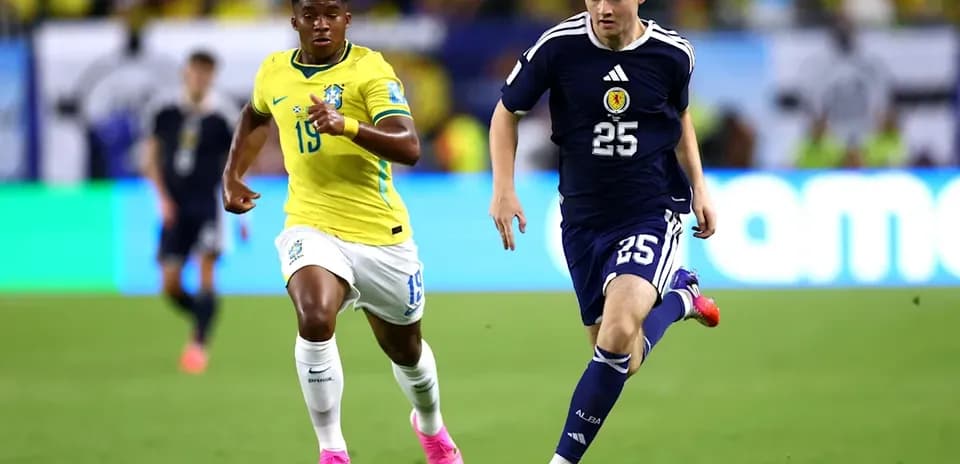 Player from Scotland dribbling past Brazilian defender