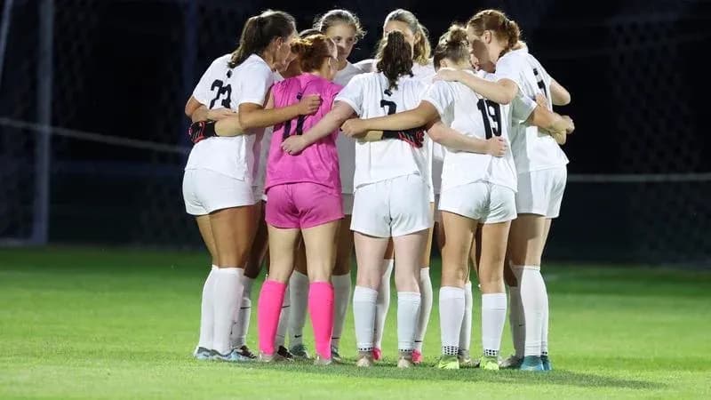 Soccer team huddled together before the match