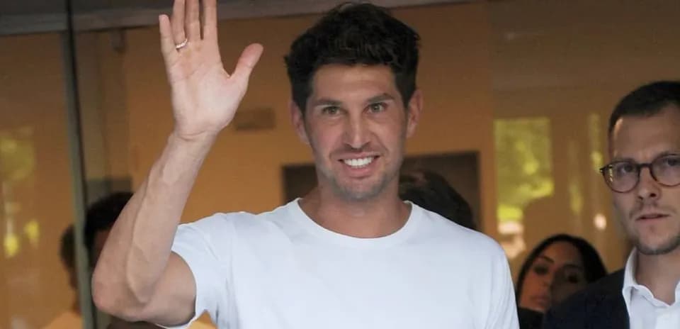 Man waving while standing with others outdoors