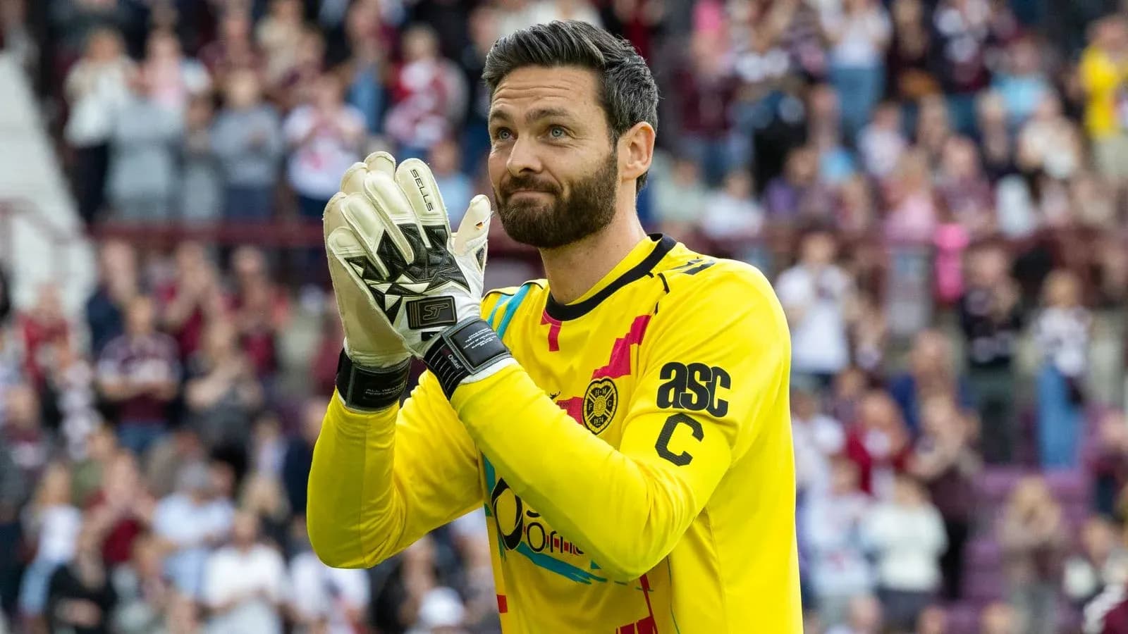 Goalkeeper in yellow jersey applauding the crowd