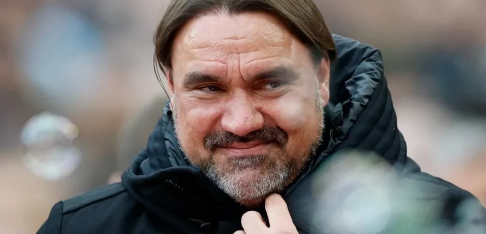Coach wearing a black jacket, smiling slightly