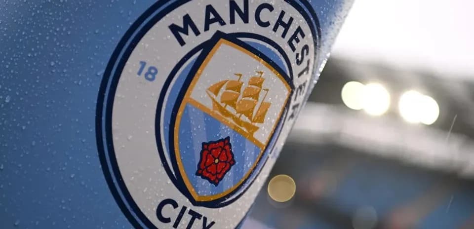 Close-up of Manchester City club emblem with raindrops