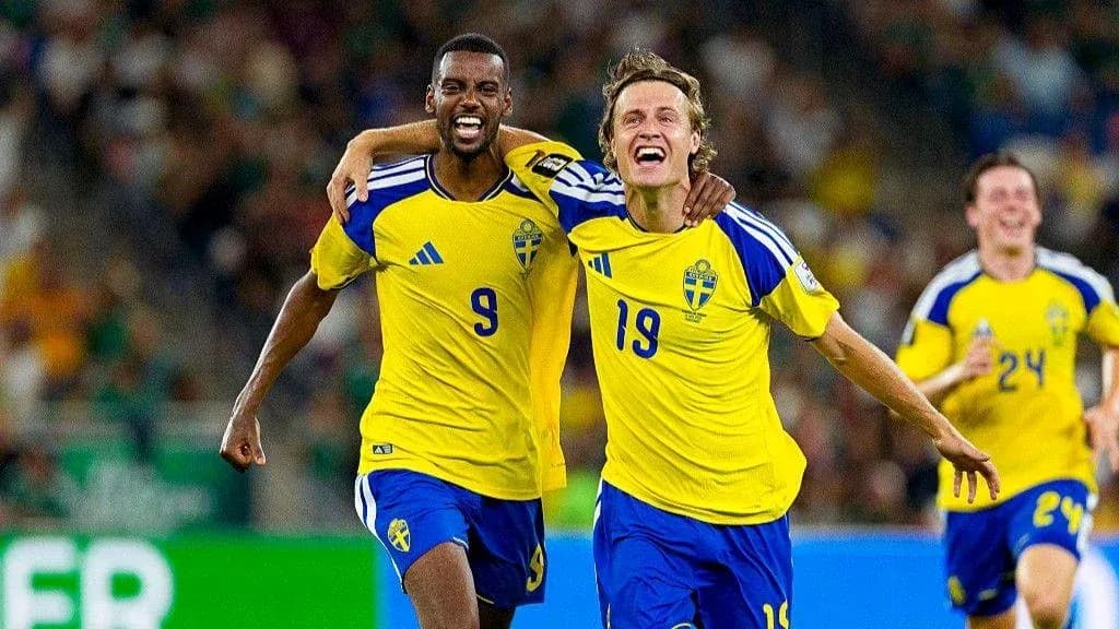 Two Swedish players celebrating a goal on the field