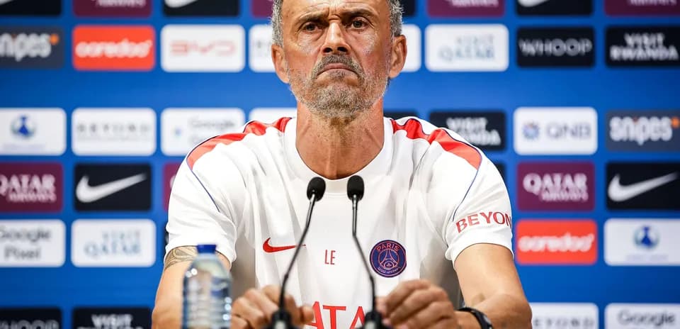 Manager at press conference with PSG branding