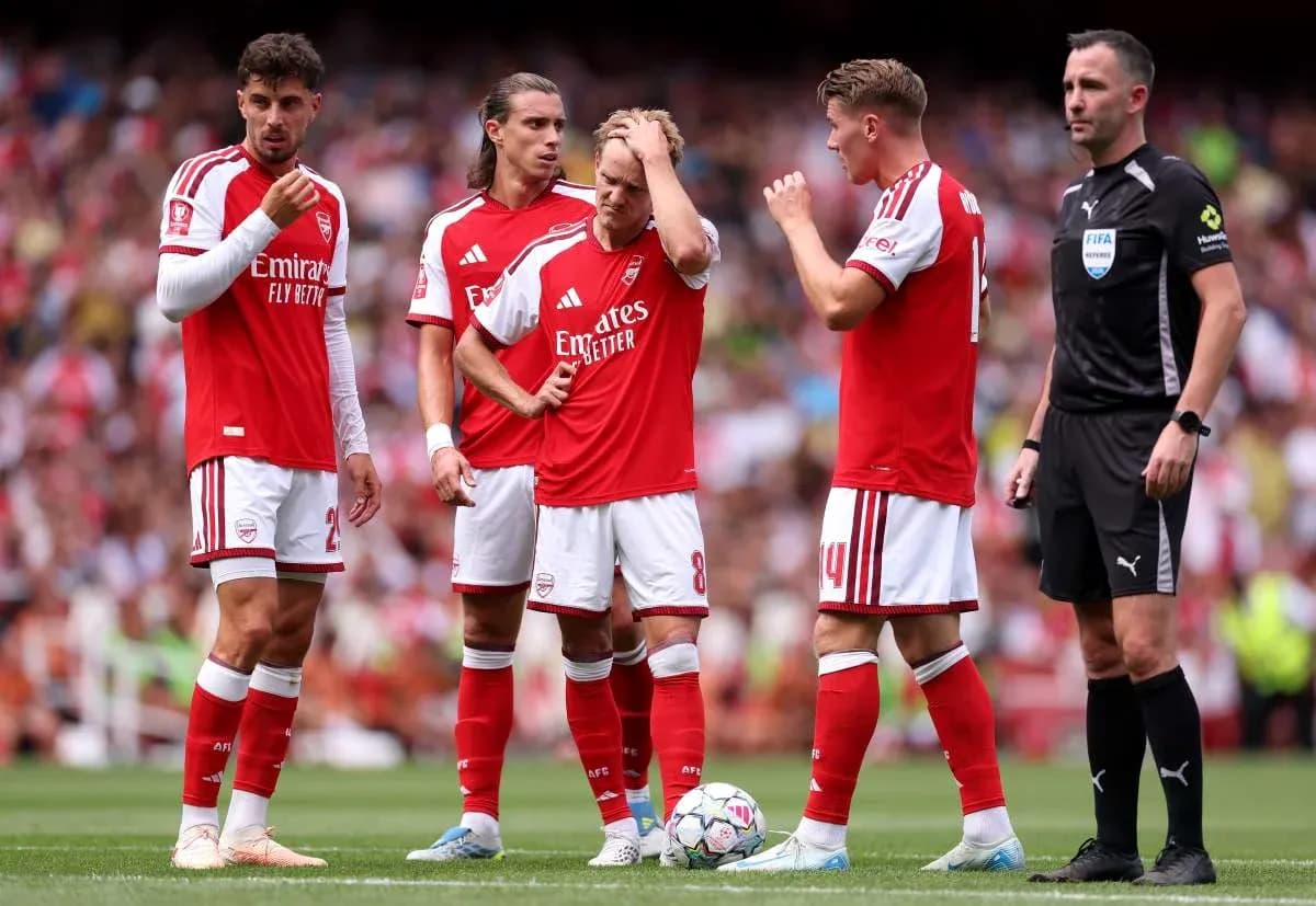 Arsenal players discussing a set piece with referee