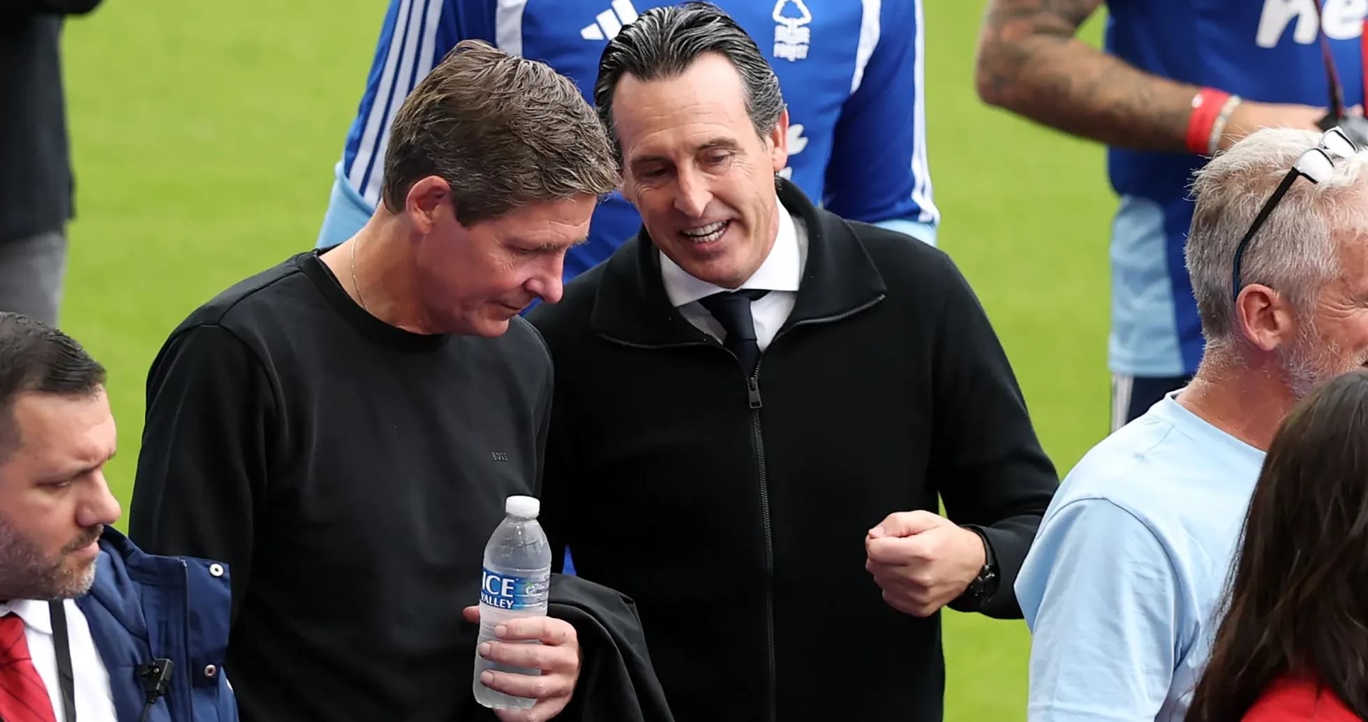 Two coaches discussing on the pitch before match