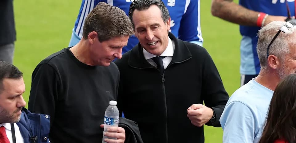 Two coaches discussing on the pitch before match