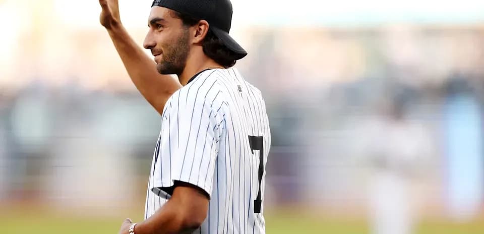 Man in Yankees jersey waving during game