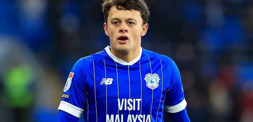 Player in blue kit during match at stadium