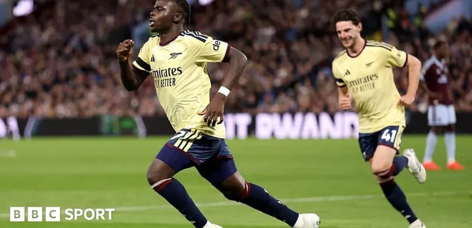 Player celebrating a goal with teammates on pitch