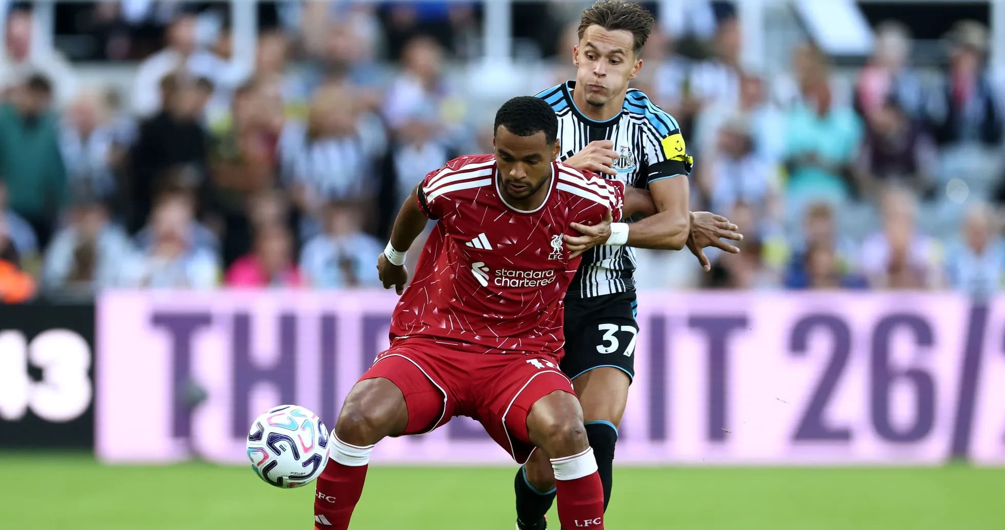 Player from Liverpool being challenged by Newcastle player