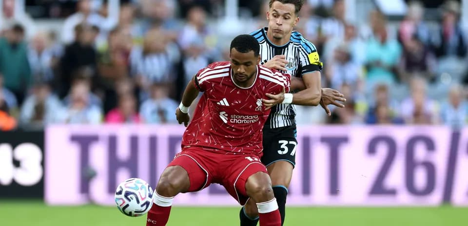 Player from Liverpool being challenged by Newcastle player