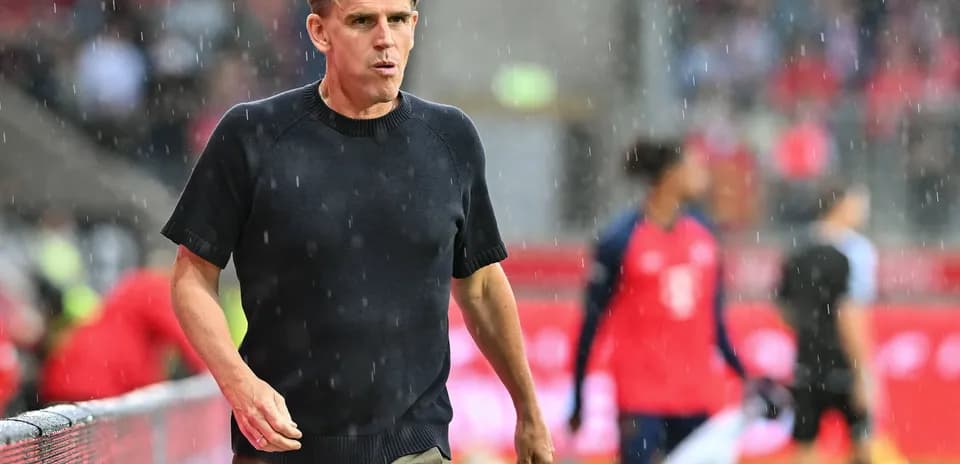 Coach walking along the sideline in rain