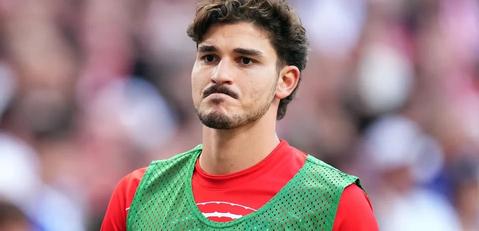 Player in training bib on sidelines during match