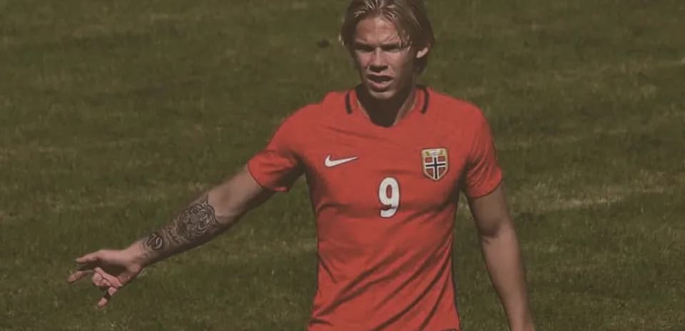 Player in red jersey signaling during match