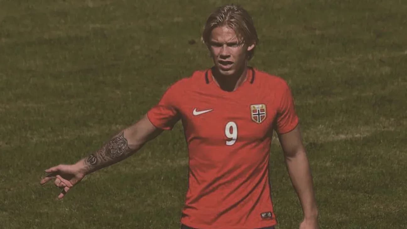 Player in red jersey signaling during match