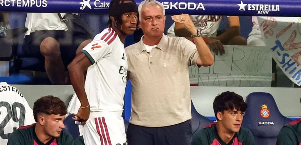 Coach discussing strategy with player on bench