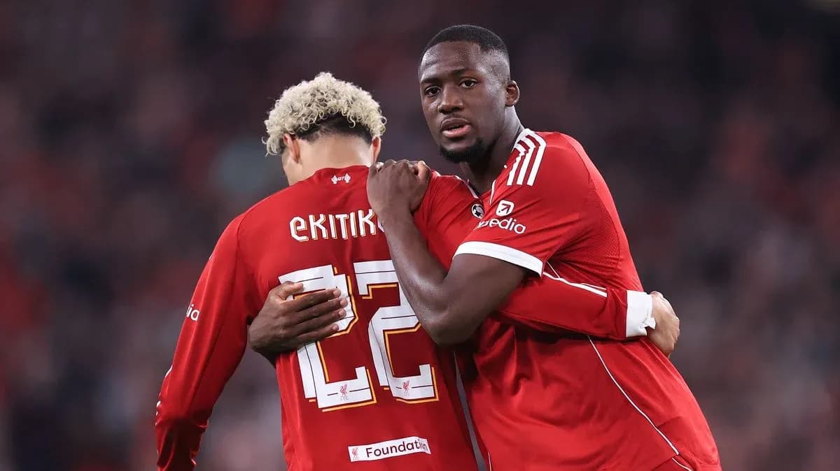 Two players embracing on the field in red jerseys