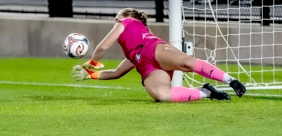 Goalkeeper diving to save the ball in goal