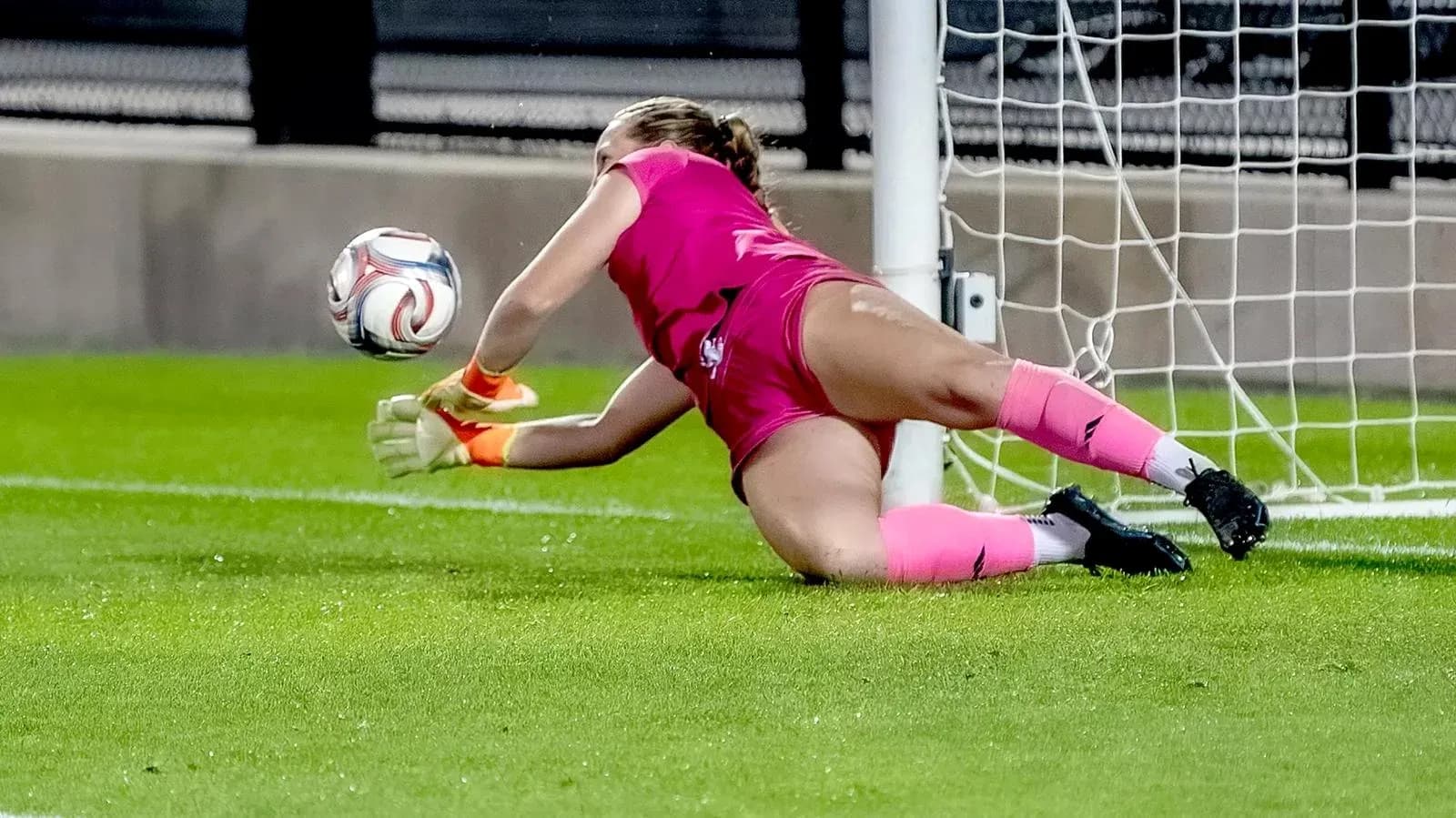 Goalkeeper diving to save the ball in goal