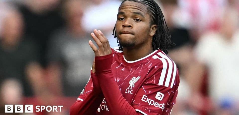 Player in Liverpool kit applauding fans during match