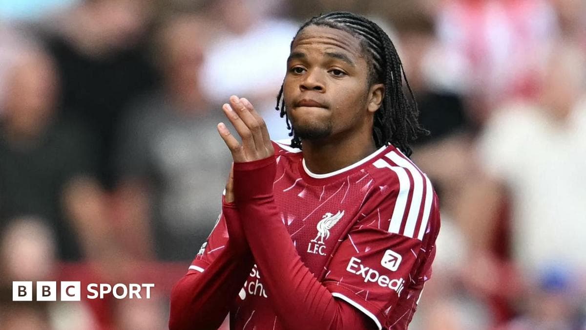 Player in Liverpool kit applauding fans during match