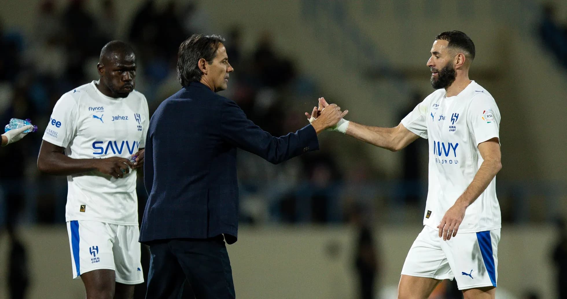 Coach greeting player during match substitution