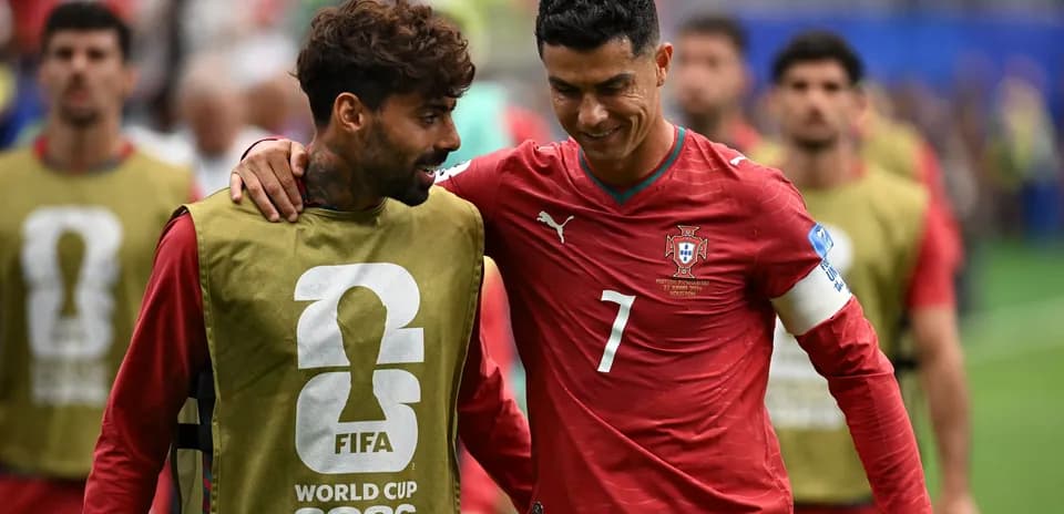 Two Portugal players walking off the field together