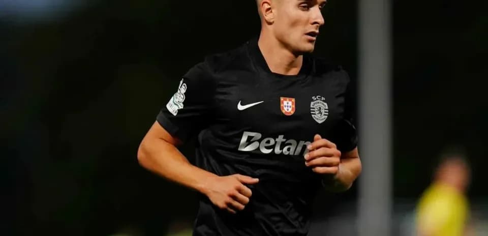 Player running during a football match in black kit