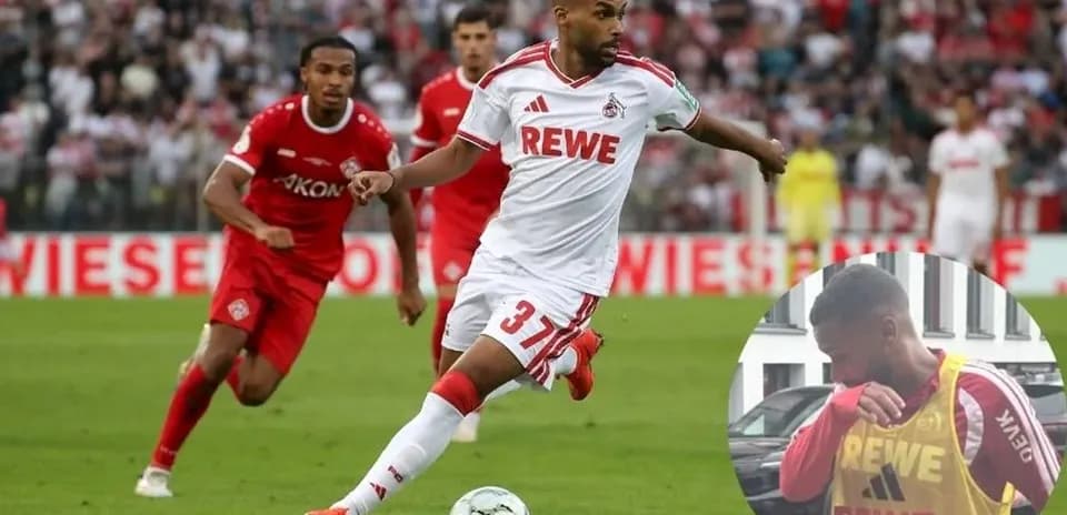 Player in white dribbling during a football match