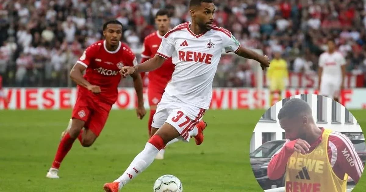 Player in white dribbling during a football match
