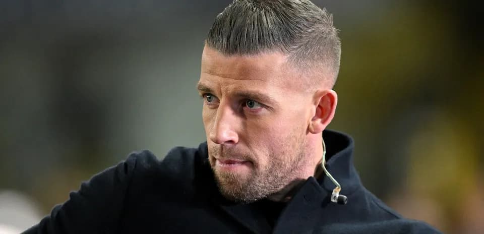 Man with short hair and beard in dark coat