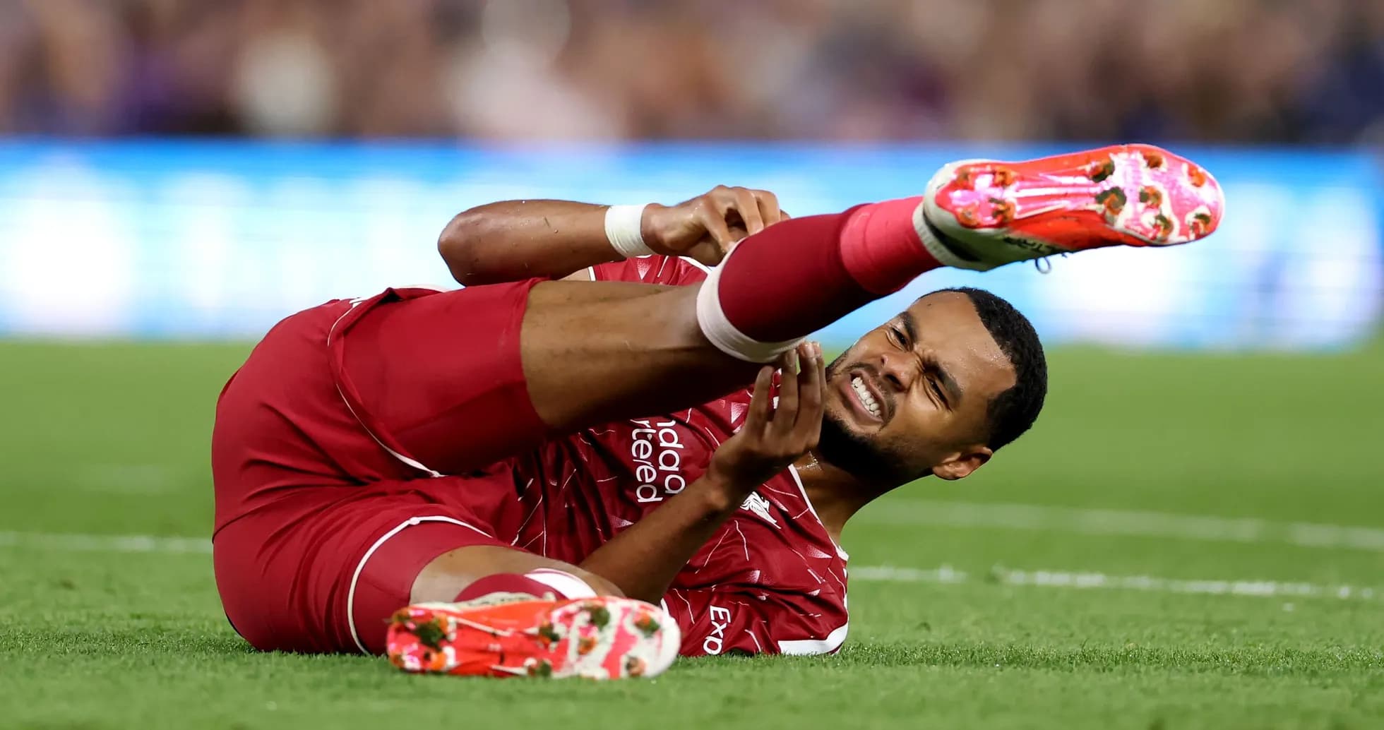 Player lying on the field, holding injured leg