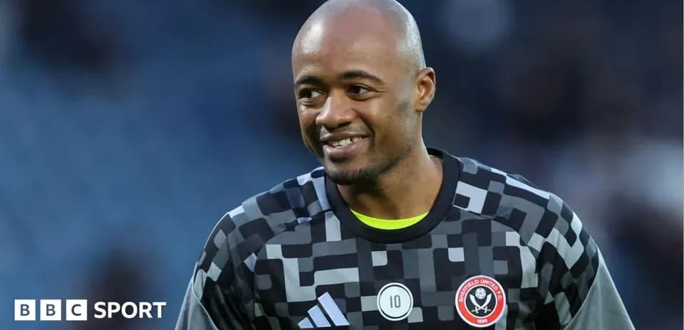 Goalkeeper in Sheffield United kit smiling on field
