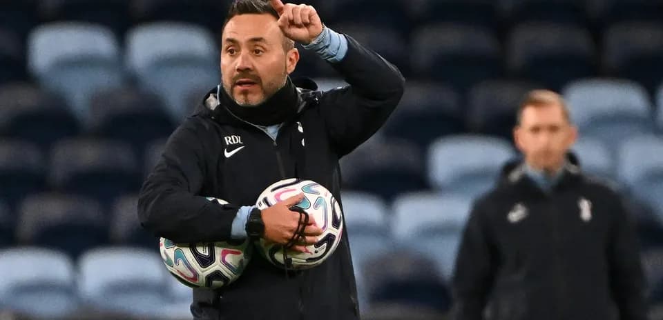 Coach instructing players while holding soccer balls