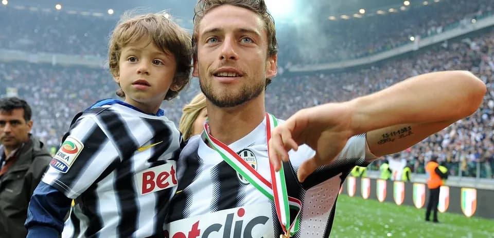 Player holding child with medal in stadium