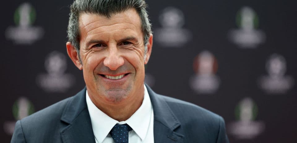 Man in suit smiling at event backdrop