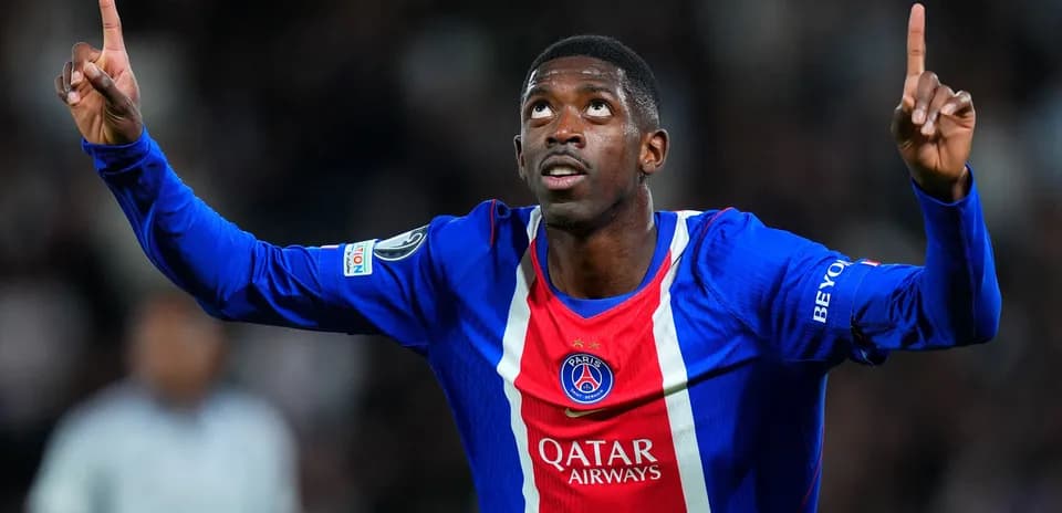 Player celebrating goal with arms raised in PSG jersey