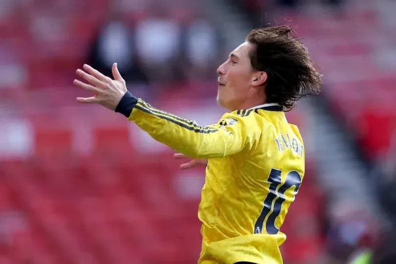 Player celebrating in yellow kit on the pitch