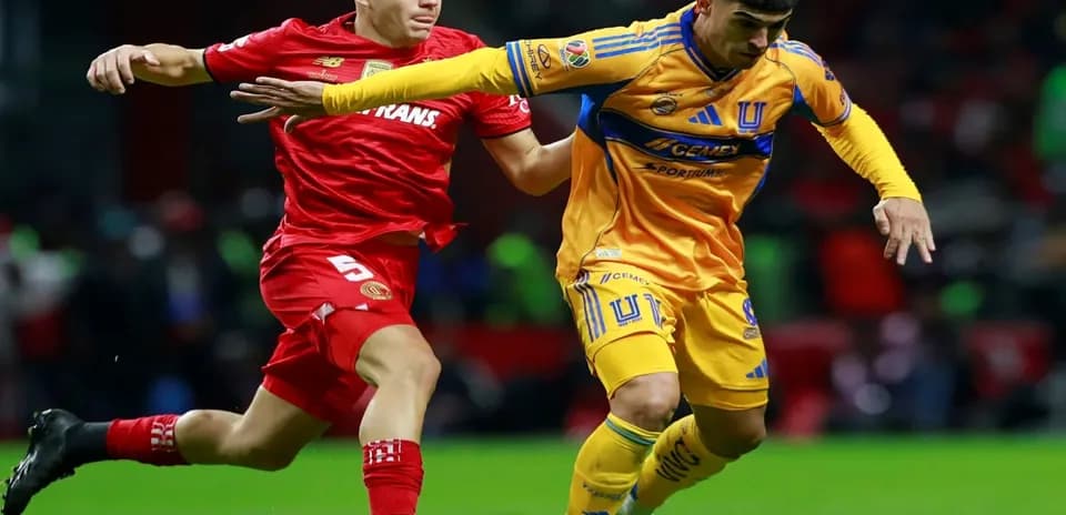 Toluca player challenges Tigres UANL player for the ball
