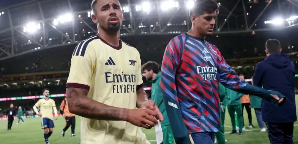 Two Arsenal players walking off the pitch after match