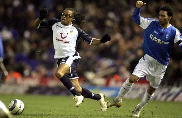 Player evading opponent during football match action