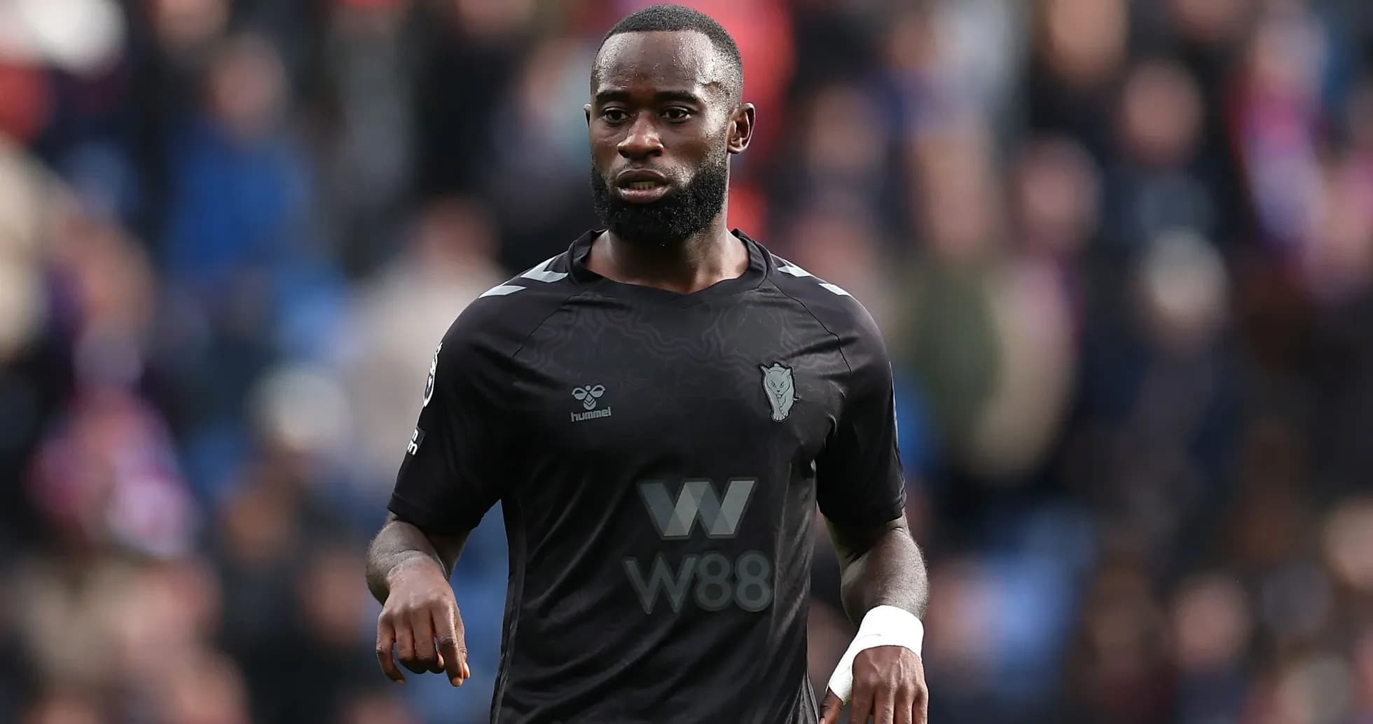 Player in black kit walking on the pitch
