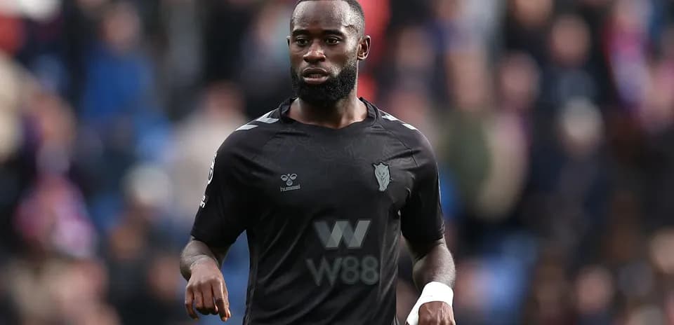 Player in black kit walking on the pitch