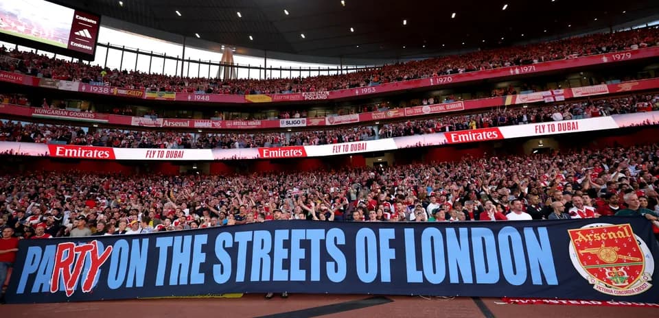 Arsenal fans holding a banner in stadium