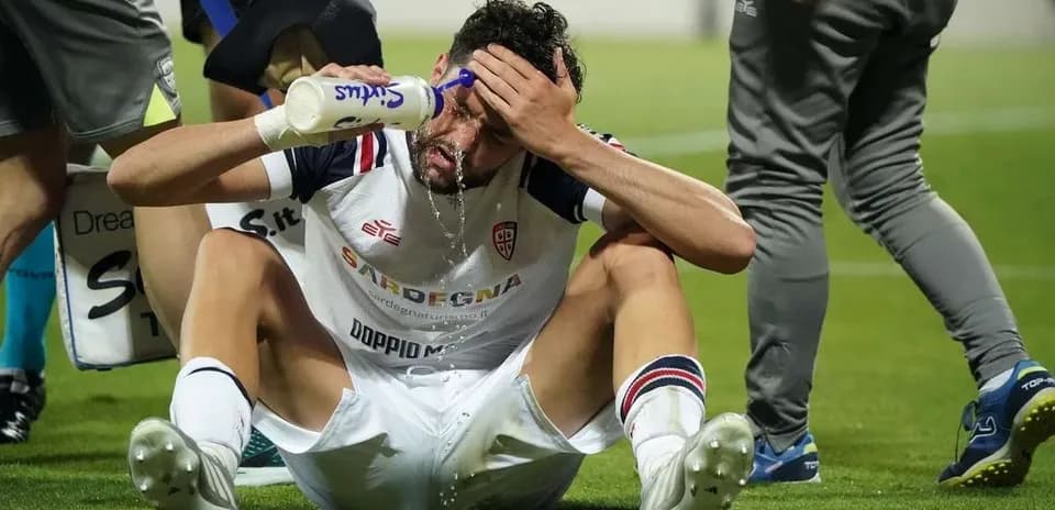 Player sitting on field pouring water on head